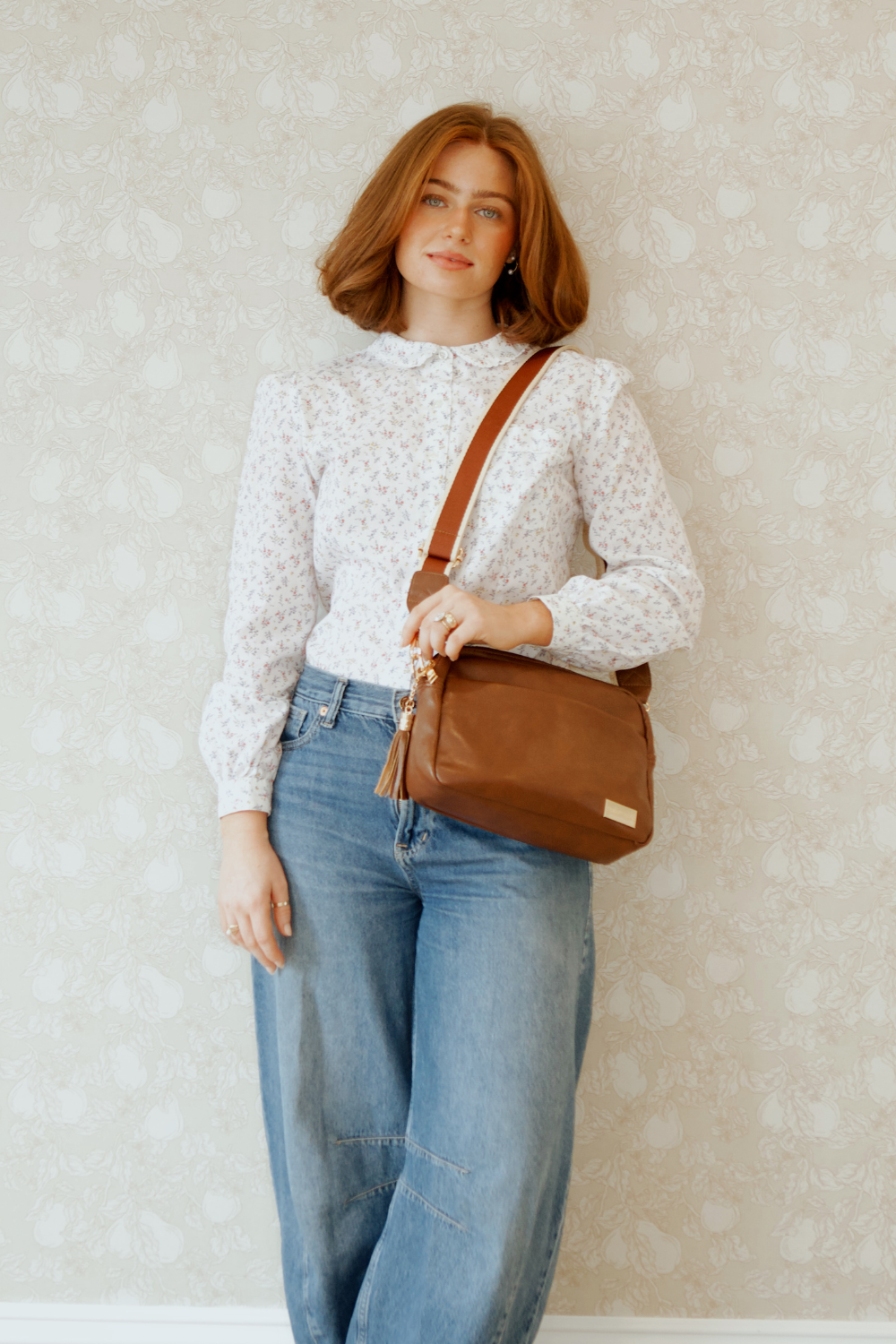 A red-haired woman modeling a Drury Road Coffee Alice Crossbody Bag: Vegan Leather Bag, Key Leash & Wallet