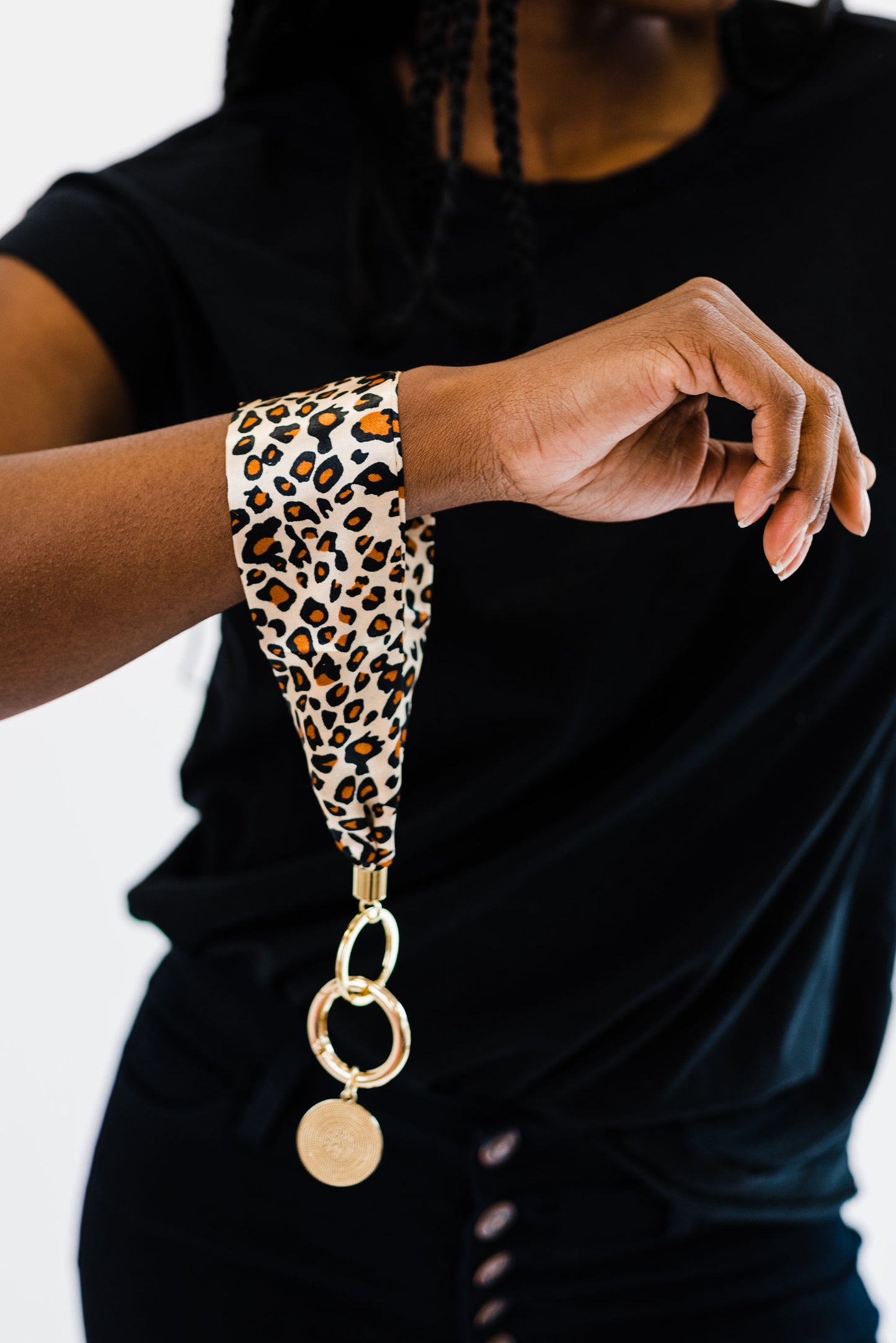 A woman wearing all black wearing a Drury Road Luna Fabric Keychain Bracelet for Women around her wrist.