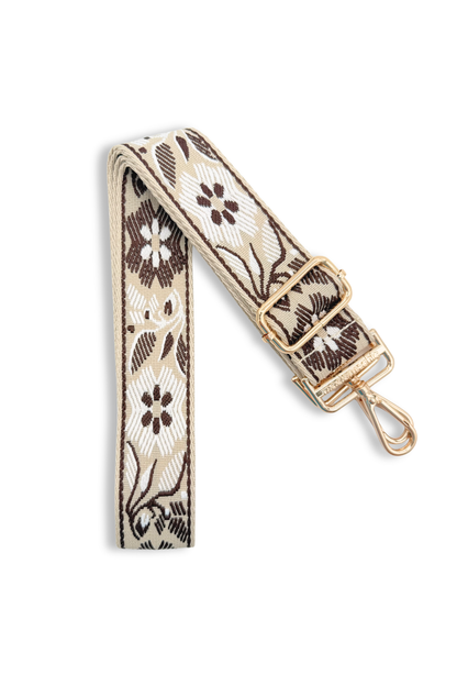 Coffee colored bag strap with a floral pattern on a white background