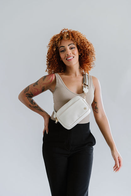 Woman wearing a cream Drury Road Willow Vegan Leather Convertible Crossbody Bag on a white background. 