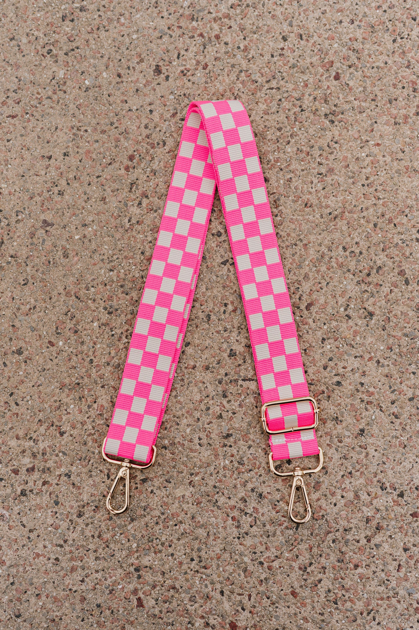 Hot pink and white Drury Road Lizzie Checkered Purse Strap for Crossbody Bags on a speckled background.