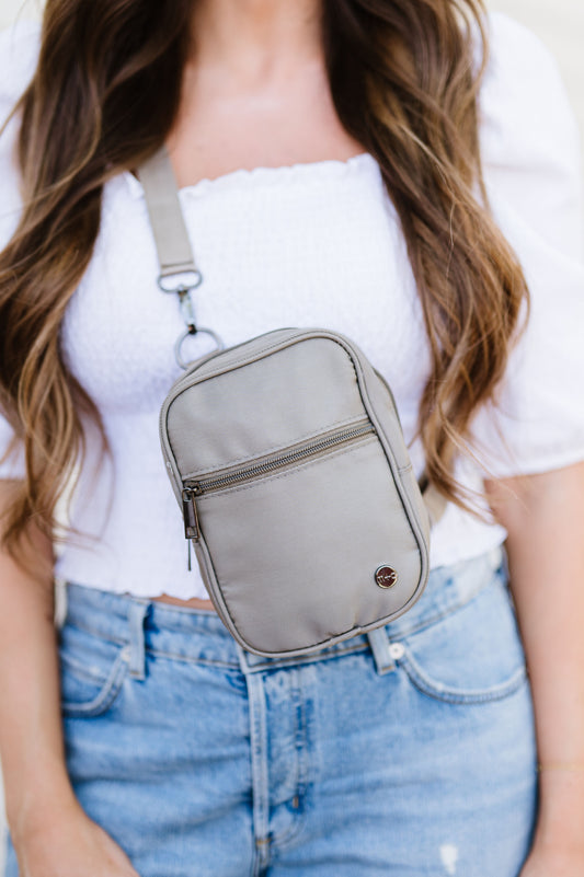 A woman wearing a grey Drury Road Lainey Convertible Crossbody Bag for Women with a white top and jeans.