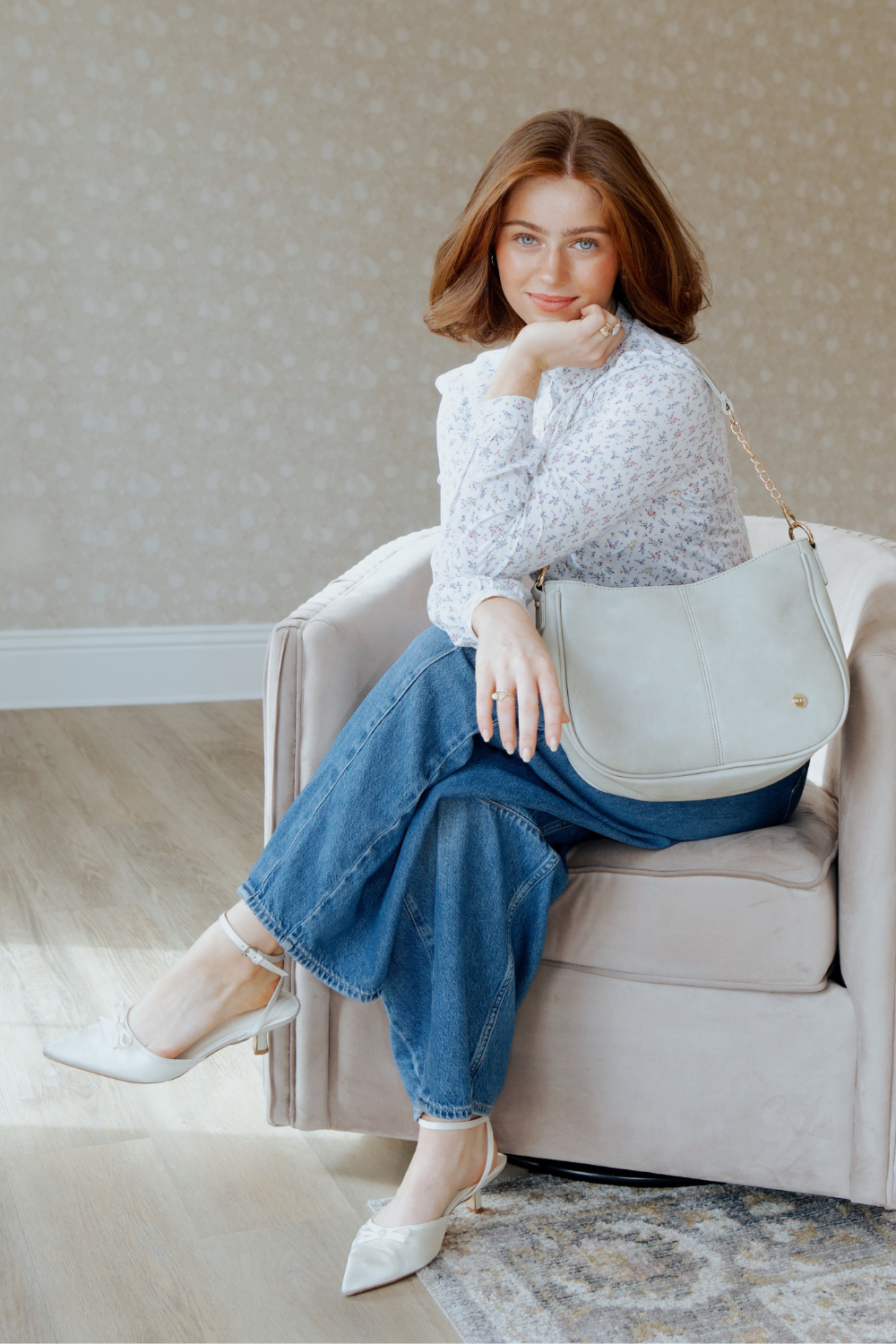 A woman posing with pebble or pale green Marissa Vegan Leather Saddle Crossbody Bag | Drury Road