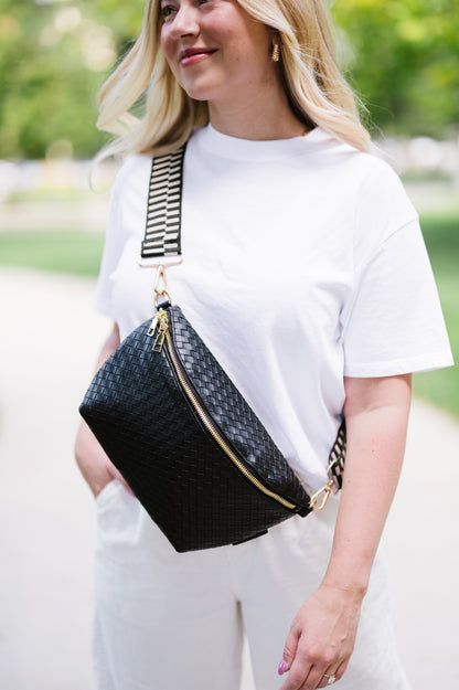 Woman wearing a white t-shirt and a black criss cross style Drury Road Rory Oversized Belt Bag for Women with a gold zipper and hardware crossbody.