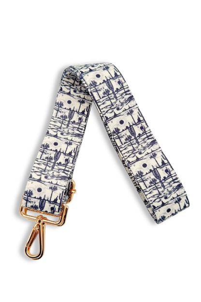 Black and white desert-patterned strap with a gold clasp on a white background