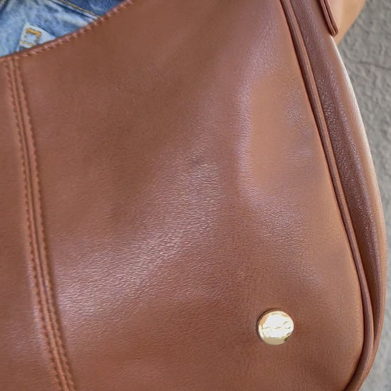 A video showing a mode posing with a variety of colors of a Drury Road Marissa vegan leather crossbody handbag.