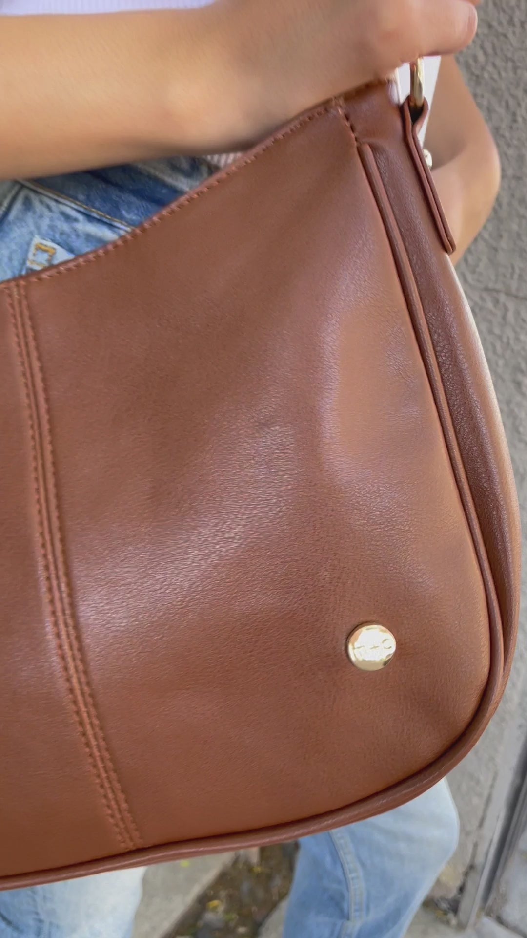A video showing a mode posing with a variety of colors of a Drury Road Marissa vegan leather crossbody handbag.