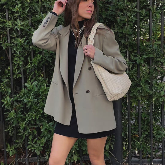 A video of a woman modeling an ivory Drury Road Kelly Woven Convertible Crossbody Shoulder Bag with included vegan leather adjustable crossbody strap outdoors.