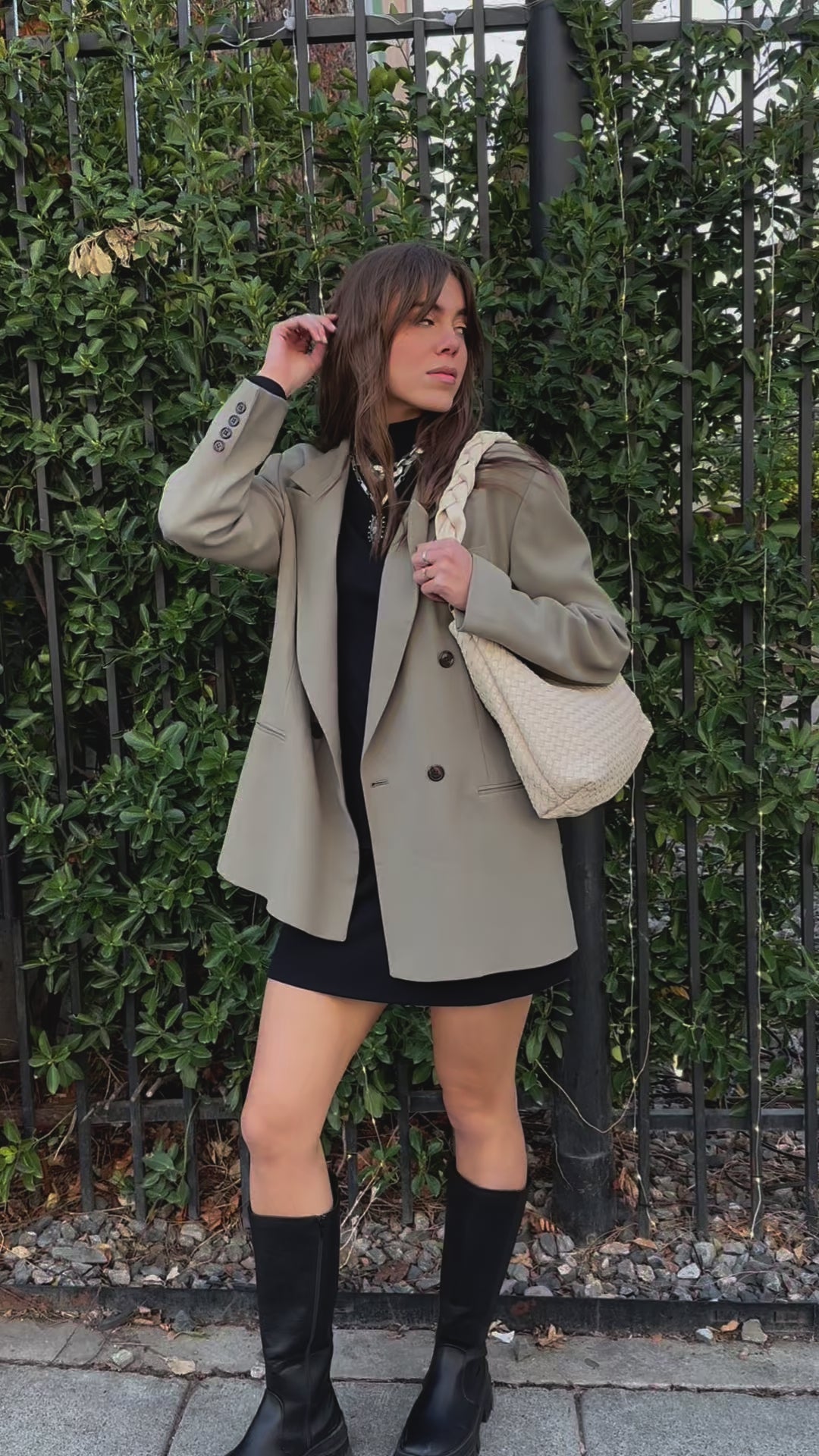 A video of a woman modeling an ivory Drury Road Kelly Woven Convertible Crossbody Shoulder Bag with included vegan leather adjustable crossbody strap outdoors.