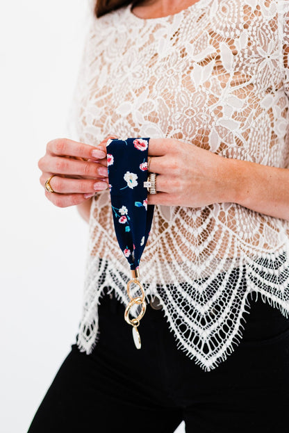 A woman holding a Drury Road Luna Fabric Keychain Bracelet for Women. 