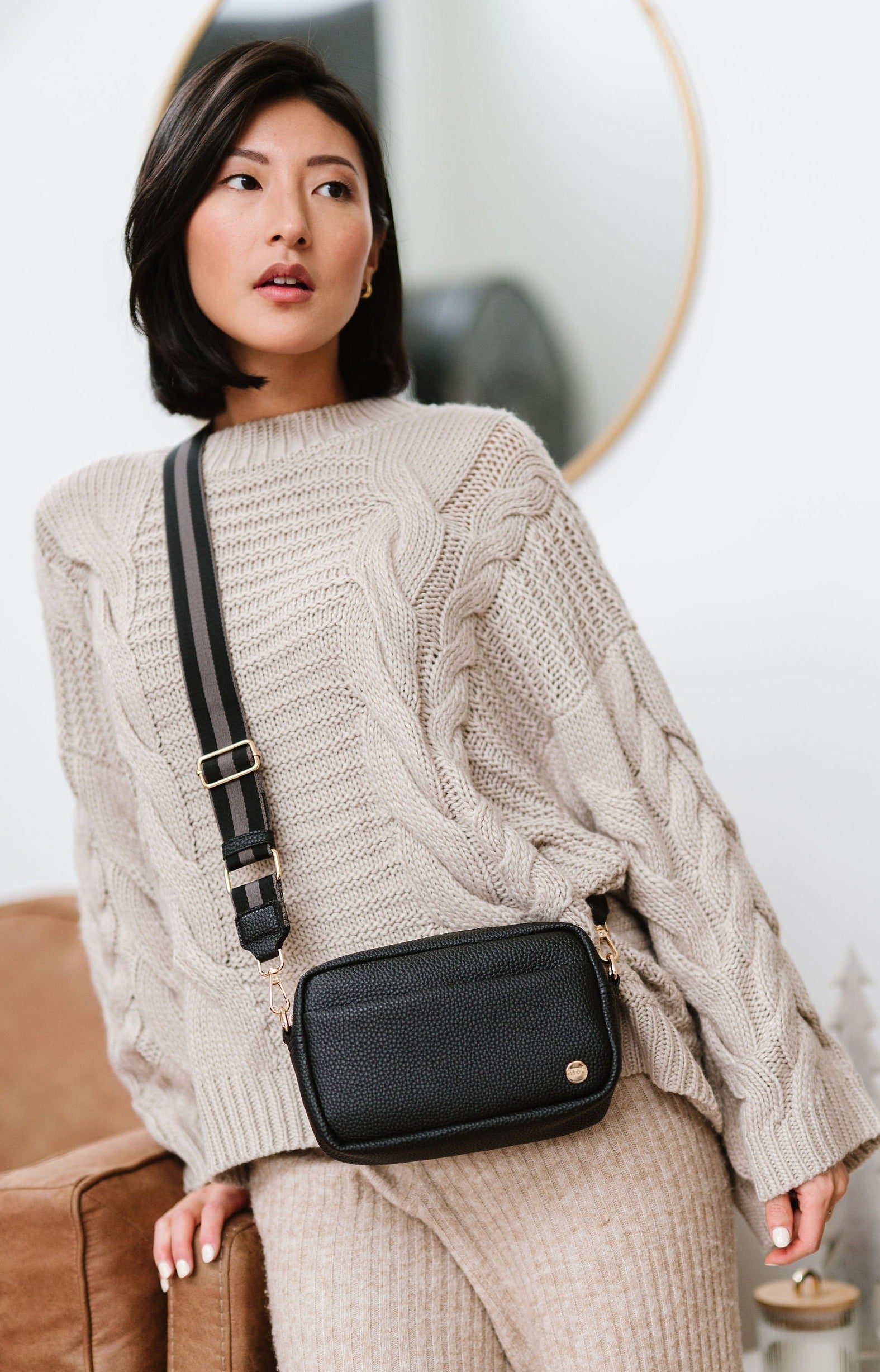 Woman wearing a black Drury Road Willow Vegan Leather Convertible Crossbody Bag on a white background. 