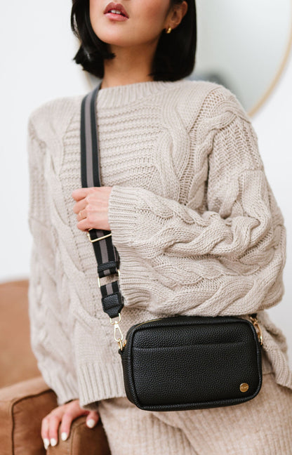Woman wearing a black Drury Road Willow Vegan Leather Convertible Crossbody Bag on a white background. 