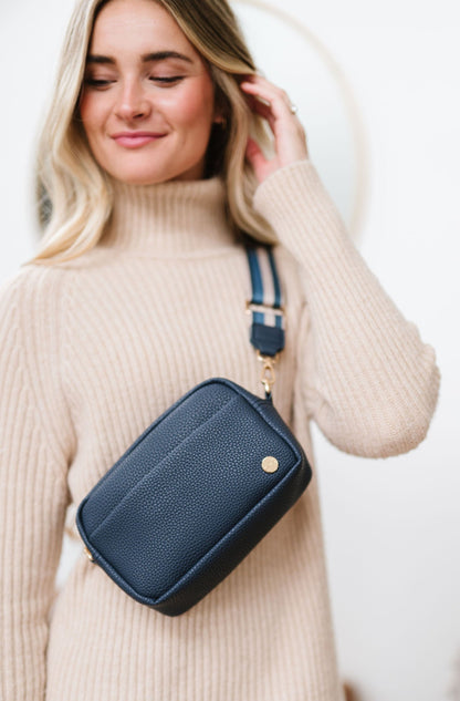 Woman wearing a blue Drury Road Willow Vegan Leather Convertible Crossbody Bag on a white background. 